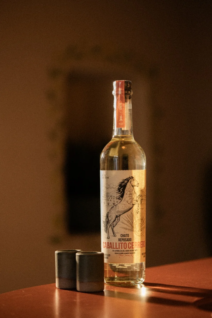 Caballito Cerrero Chato Reposado mezcal bottle with tasting cups at Pūblico Mezcaleria Mykonos