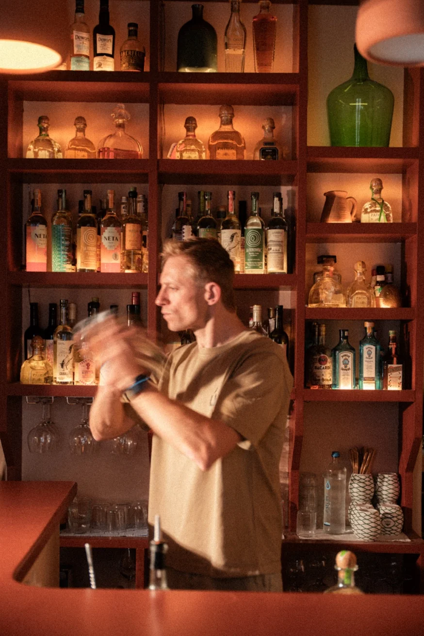 Bartender shaking cocktails at Pūblico Mezcaleria — the best cocktail bar in Mykonos Town