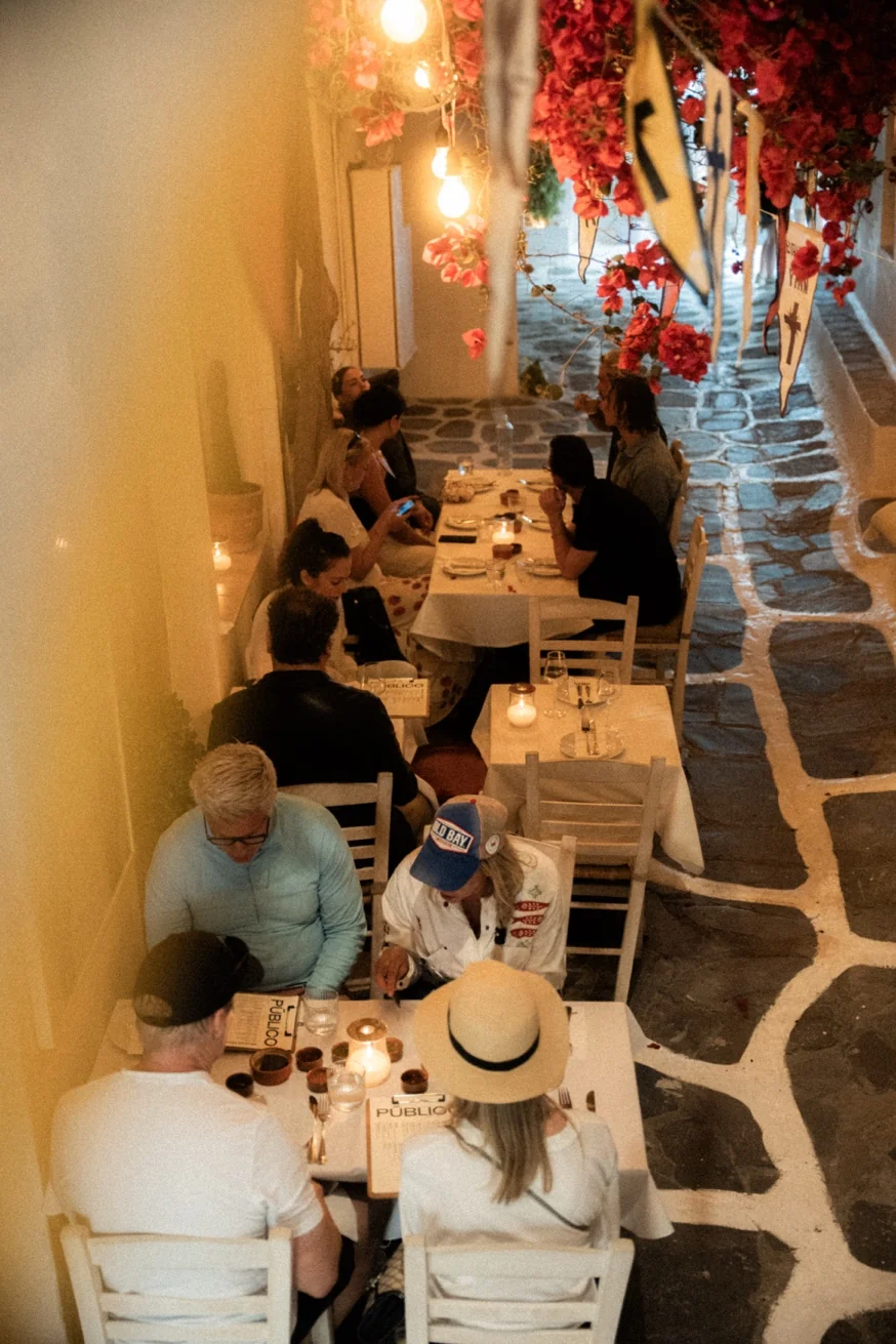 Sharing dishes and wine at Pūblico restaurant Mykonos