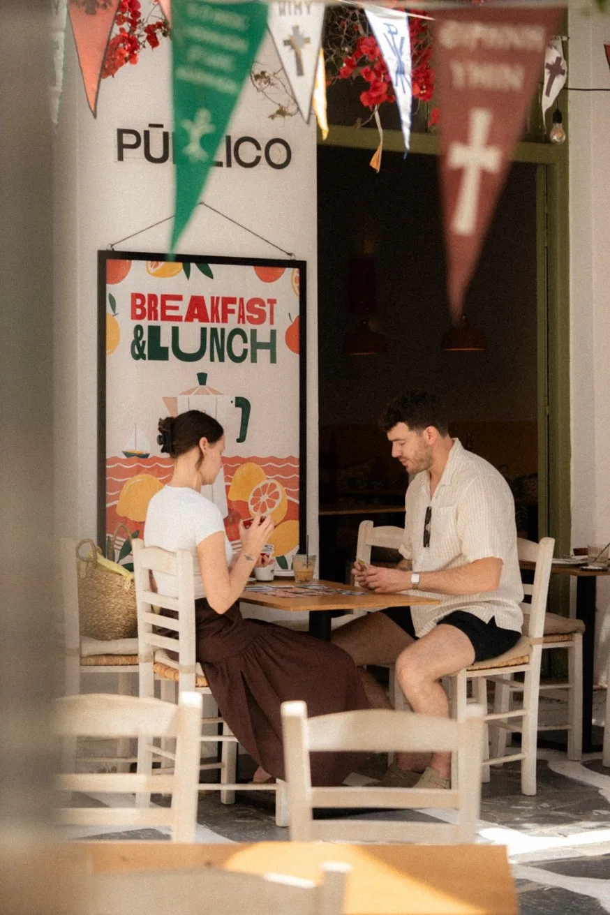 Couple dining at Pūblico — Mykonos Brunch Club breakfast and lunch terrace in Mykonos Town, open daily 09:00–16:00